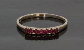 14 karaats witgouden vintage dames rij ring met 7 robijnen, klassiek vintage sieraad. De ringmaat is 20,25(63), elegante uitvoering, stijl minimalistisch, breedte ring 2,6mm. Ook te dragen als aanschuifring, gestempeld met het 585 goudmerk, Hollands gekeu