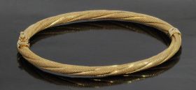 14 karaats gouden fraaie slavenarmband met bewerkt decor. Solide uitvoering van 6,50 gram, omtrek binnenzijde gemeten is 17cm(59x52mm), breedte band 4mm. Met klik magneetslot en veiligheidsachtje, gestempeld met het 585 goudmerk Hollands gekeurd eikenblaa