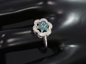 Witgouden dames ring centraal gezet met 7 lichtblauwe zirkonia steentjes omlijst door 6 briljant geslepen diamantjes. Verfijnd gemaakt juweel, de ringmaat is 16,5(52), doorsnee ringkop 10mm. Conditie fraai, getoetst als zijnde 10 karaats goud BWG 417/1000