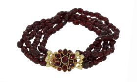Antieke 4-strengs granaten dames armband aan fraaie 14 karaats gouden entourage bloemvormige sluiting(14mm). Draaglengte van dit sieraad is 17cm(smalle damespols), fijne kralen met een doorsnee van 3,5mm. Slot gestempeld met het 585 goudmerk, Hollands gek
