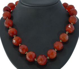 Robuuste vintage ketting gemaakt van facetgeslepen carneool edelstenen aan 14 karaats gouden karabijnsluiting. Draaglengte van dit sieraad is 45cm, kralen oplopend geregen van 12mm tot 18mm, zware uitvoering van 124 gram. Conditie fraai, kralen op double