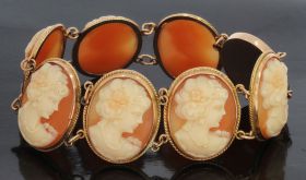 14 karaats gouden antieke armband met 7 schelpcamee portretten van een jongedame in koordrandomlijsting. Betreft een handgemaakt juweel, draaglengte is 17,5 / 18cm, breedte schakels 25mm, totaalgewicht 19 gram. Conditie mooi antieke staat, dit sieraad wor