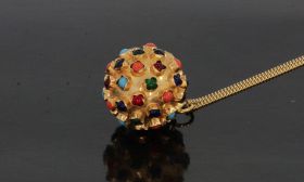 Fraaie 14 karaats geelgouden bolvormige Sputnik hanger volgezet met steentjes waaronder amethist, bloedkoraal, turkoois en gekleurd glas. Doorsnee van de bol is 18mm, draaglengte inclusief hangoogje 24mm, gewicht 4,20 gram. Conditie uitmuntend, levering e