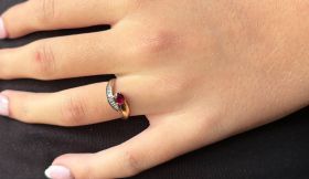 18 karaats geel- en witgouden dames vintage ring met een centrale robijn(ca. 0,25ct) omlijst door 6 briljant geslepen diamantjes. De ringmaat is nu 16(50), verstelbaar aan de onderzijde tot de gewenste maat, breedte ringkop 7mm. Gestempeld met het 750 gou
