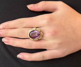 14 karaats geelgouden dames ring met Amethist edelsteen in fraai bewerkte zetting. Betreft een solide uitvoering van 6,50 gram, de ringmaat is 18,25(57), afmetingen ringkop 25x20mm. Conditie fraai, gestempeld met het 585 goudmerk, Hollands gekeurd eikenbl