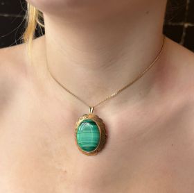Grote 14 karaats geelgouden ketting hanger, tevens te dragen als broche, met een cabochon geslepen Malachiet edelsteen. Robuuste uitvoering van 13 gram, afmetingen zijn 40x30mm, hoogte 10mm, gestempeld met het 585 goudmerk, Hollands gekeurd eikenblaadje. 