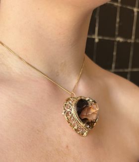 Exclusieve zeer grote 14k geelgouden ketting hanger, tevens te dragen als broche, met hartvormige facetgeslepen rookkwarts. Uniek en handgemaakt sieraad voor de verzamelaar met een gewicht van maar liefst 32 gram, de afmetingen zijn 40x40mm, hoogte 20mm. 