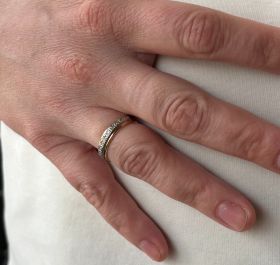 14 karaats geelgouden brede bandring met 10 diamanten van 0,01ct per stuk in witgouden zetting. Betreft een solide uitvoering van 5 gram, de ringmaat is 19,75(62), breedte ring 5mm. Gestempeld met het 585 goudmerk, Hollands gekeurd eikenblaadje, unisex si