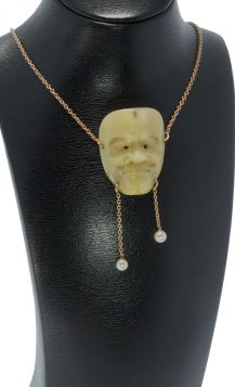 18 karaats geelgouden anker schakel collier met antiek benen hanger in de vorm van een Japans masker(35x27mm) gezet met diamantje en parel(5mm) pampel. Draaglengte van dit sieraad is 37cm, kort model hoog in de hals te dragen, fijne schakel met een breedt