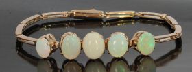 Antieke rosegouden staafjes armband met 5 cabochon geslepen opalen met fraai wisselend kleurenspel. Centrale opaal edelsteen 11x8mm, aflopend naar 8x6mm, draaglengte van dit juweel is 18cm, breedte staafjesschakel 2,2mm, gewicht 10,70 gram. Conditie mooi 