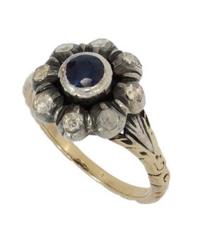 14 karaats gouden antieke ring gezet met centrale saffier(4mm) omlijst door 8 roosgeslepen diamanten(2,5mm per stuk) in zilveren zetting. Handgemaakt sieraad, de ringmaat is 16,25(51), doorsnee ringkop 12mm, gewicht 4,40 gram. Gestempeld met het 585 goudm