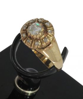 14 karaats gouden antieke ring met een grote centrale roosgeslepen diamant van ca. 5mm omlijst door 9 kleinere steentjes. De ringmaat is 18,25(57), doorsnee ringkop 11mm, gewicht 3,50 gram. Conditie fraai antieke staat, samengesteld juweel, scheen van lat